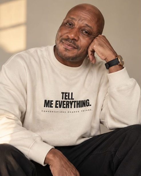Man wearing TELL ME EVERYTHING cream luxury sweatshirt